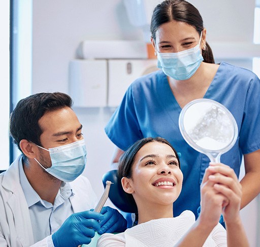 Patient looking at reflection in mirror with dentist