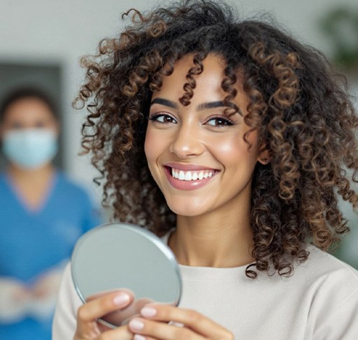 Woman smiling while holding a small mirror