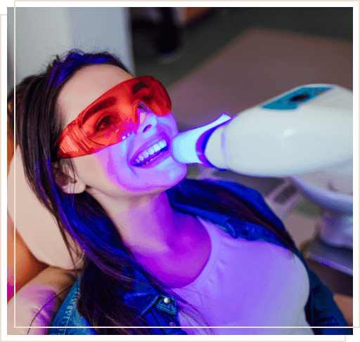 Woman getting her teeth professionally whitened in dental office