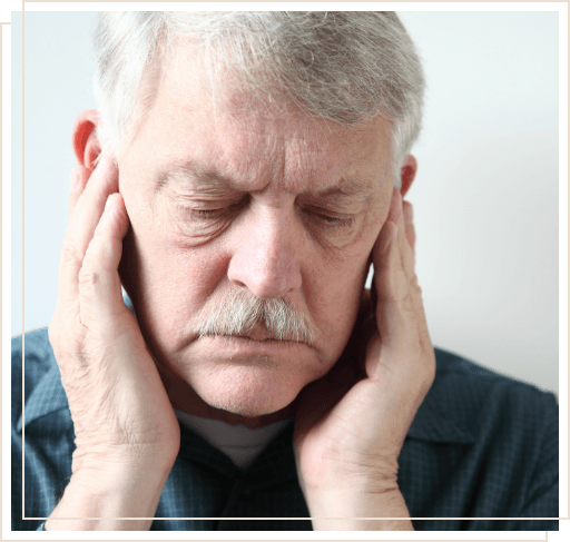 Man touching his temples with eyes closed