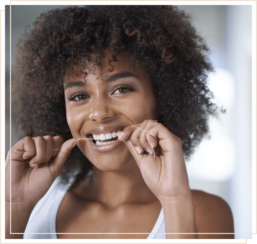 Woman smiling while flossing her teeth