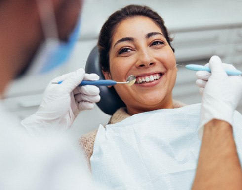 Patient smiling at dentist during routine checkup