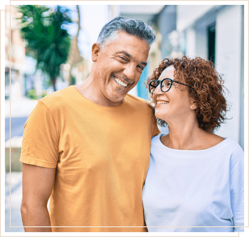 Man and woman smiling together on city sidewalk