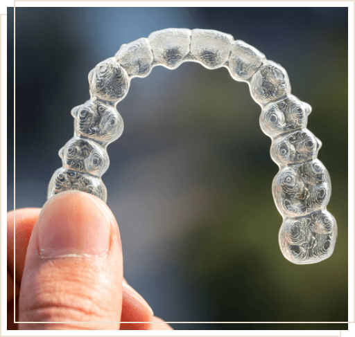 Close up of person holding Invisalign tray