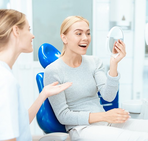 A woman looking at her newly improved smile