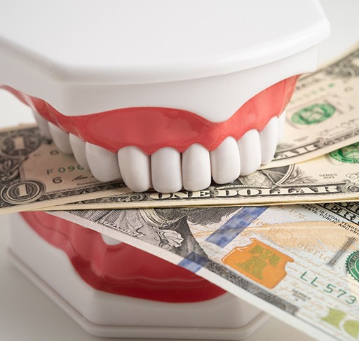 Fake teeth biting dollar bills