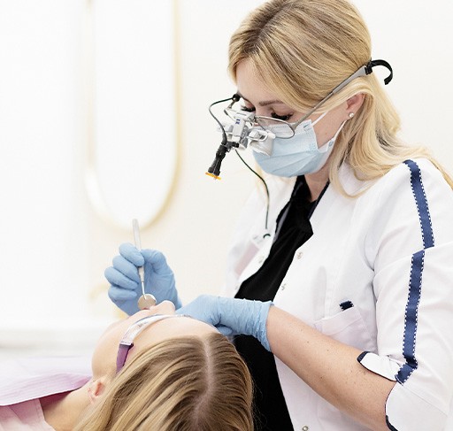 Doctor Henkin wearing dental binoculars while treating a patient