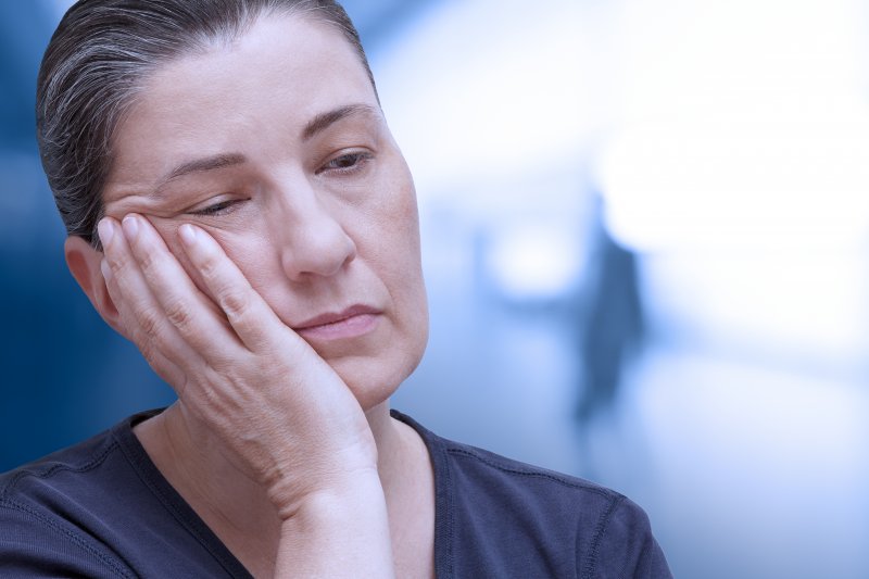 Patient holding their cheek due to a dental emergency