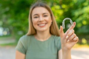 Woman holding her Invisalign tray